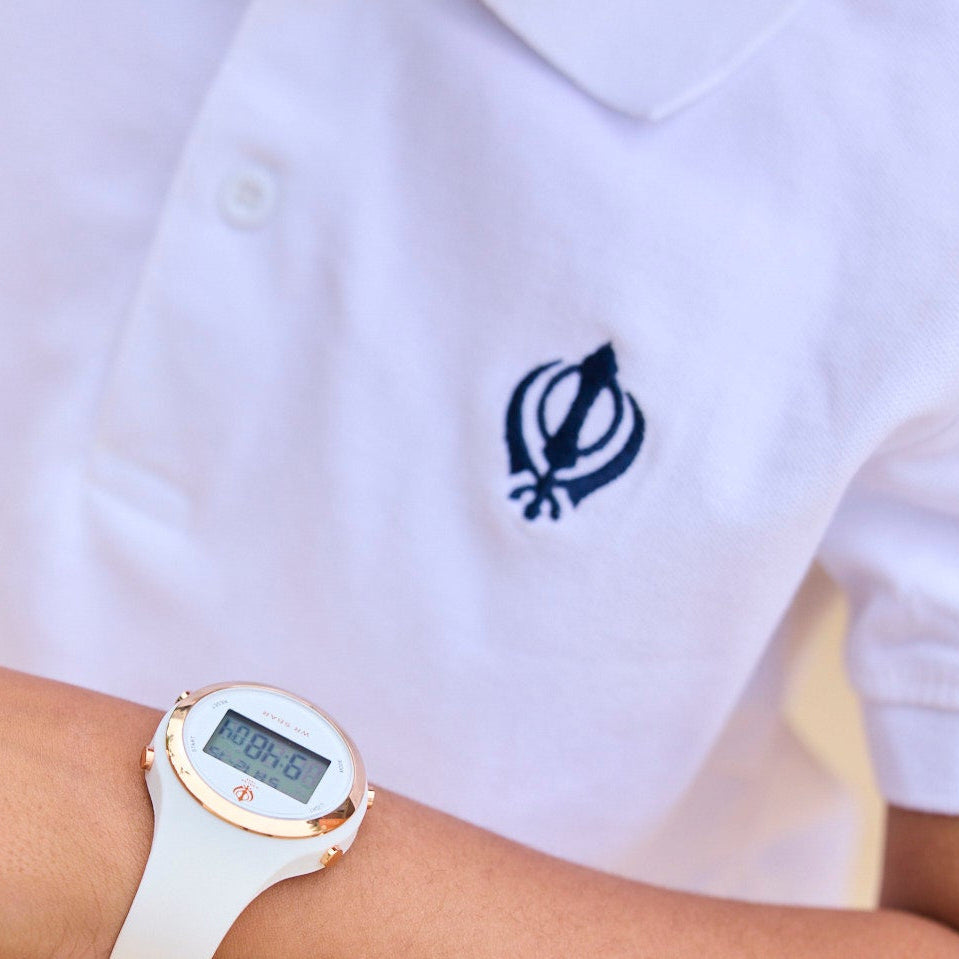 Person wearing a white polo shirt with a logo and a digital watch on a neutral background